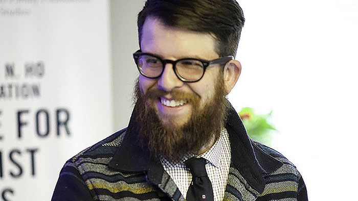 brown haired man with beard and glasses smiling